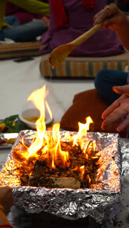 Vertikales-Video,-Nahaufnahme-Von-Gläubigen,-Die-In-Havan-Smaghri-Ins-Feuer-Opfern,-Zeremonie-Für-Navratri-1